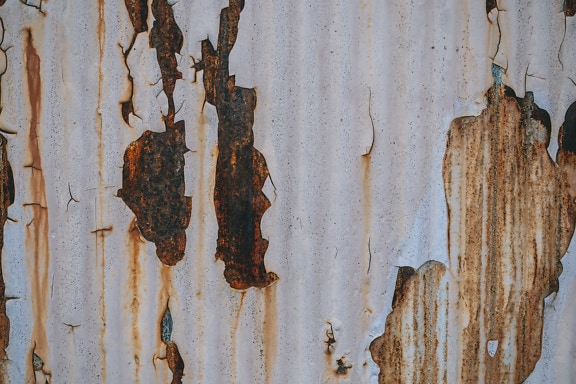 Rusted metal surface with peeling white paint