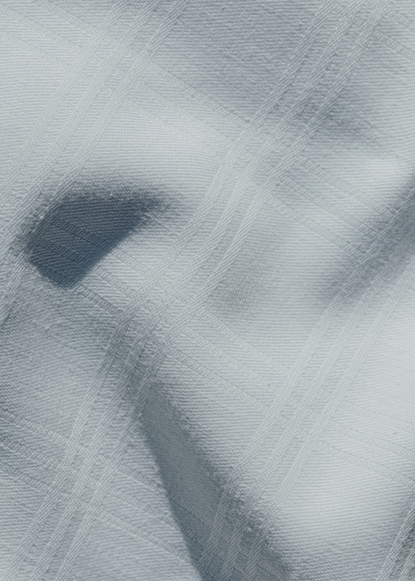 พื้นผิวของผ้าฝ้ายสีขาวที่มีลวดลายเรขาคณิตสี่เหลี่ยมผืนผ้า