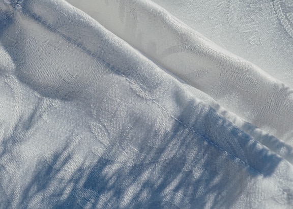 Tekstur kain katun putih dengan bayangan di atasnya