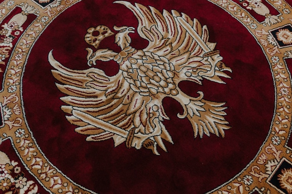 Red and gold woven liturgical rug with illustration of two headed eagle on it