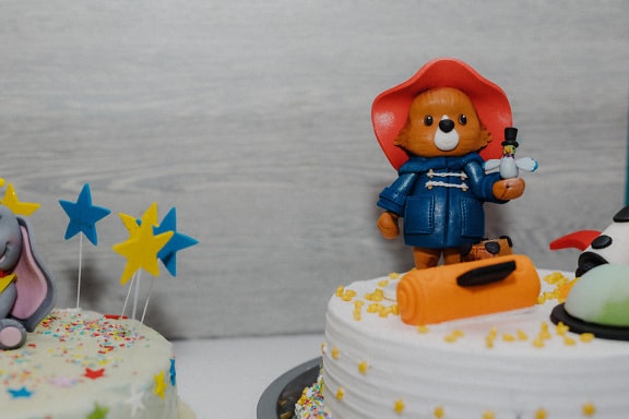 Birthday cake with a bear figurine decoration on top