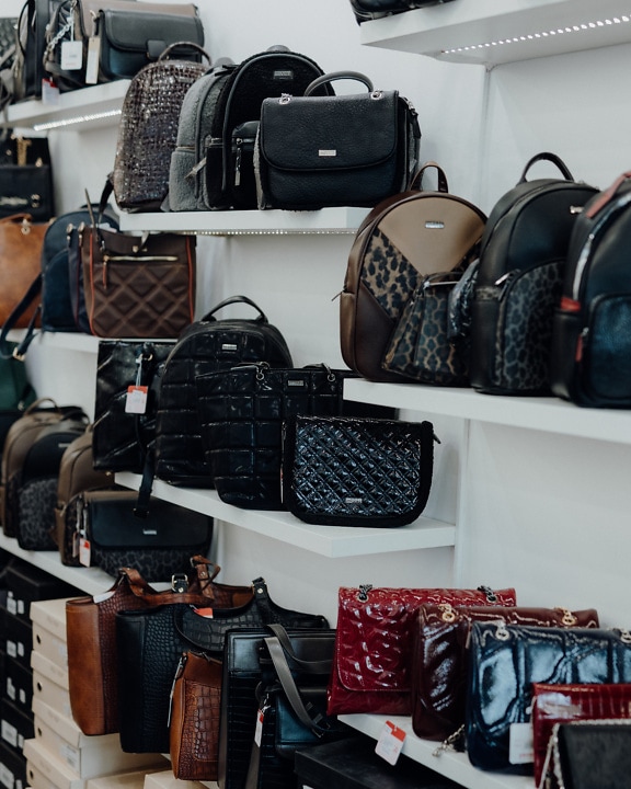 Shelf with many fashionable leather handbags on it