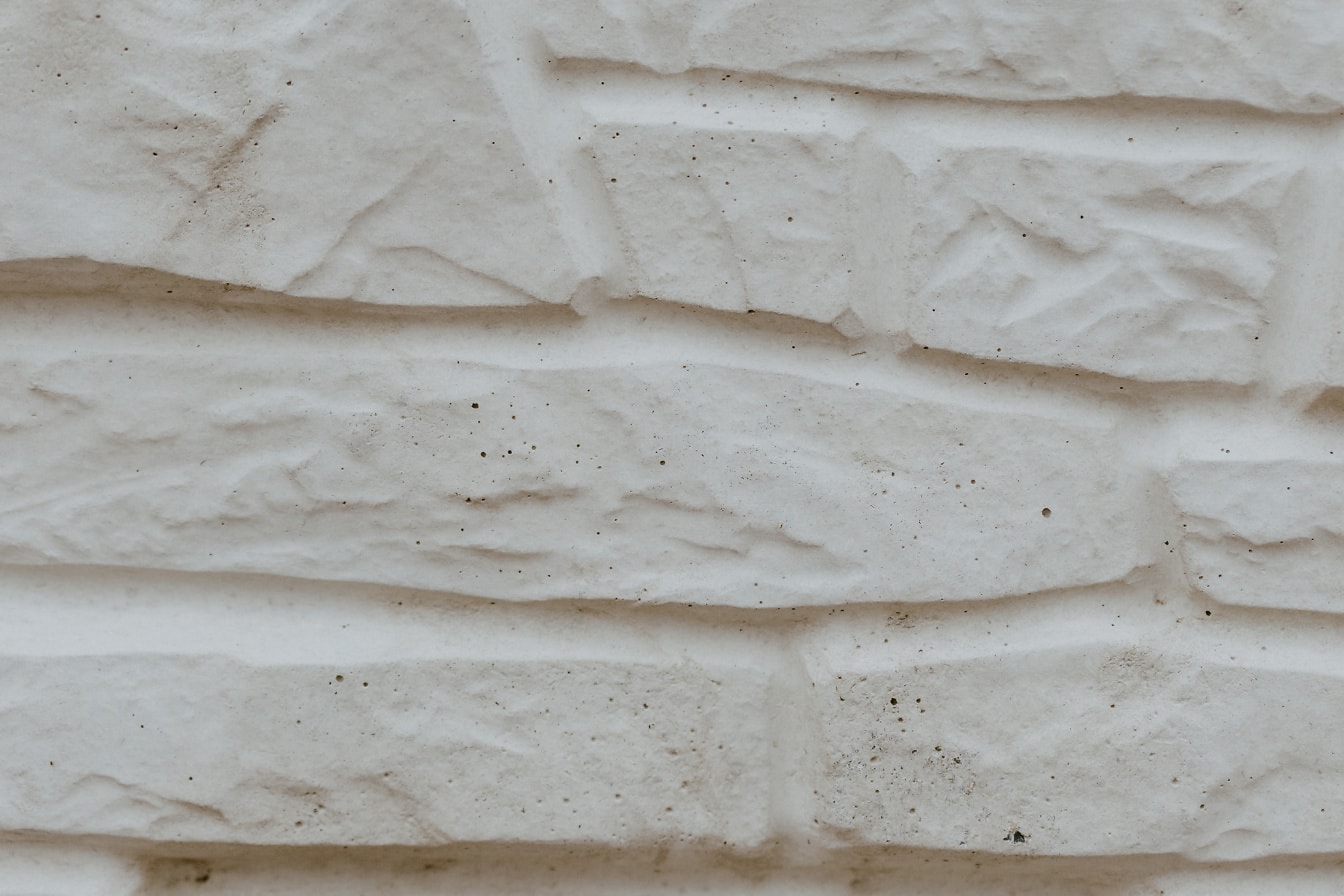 Шероховатая текстура бежевой стены из искусственного камня