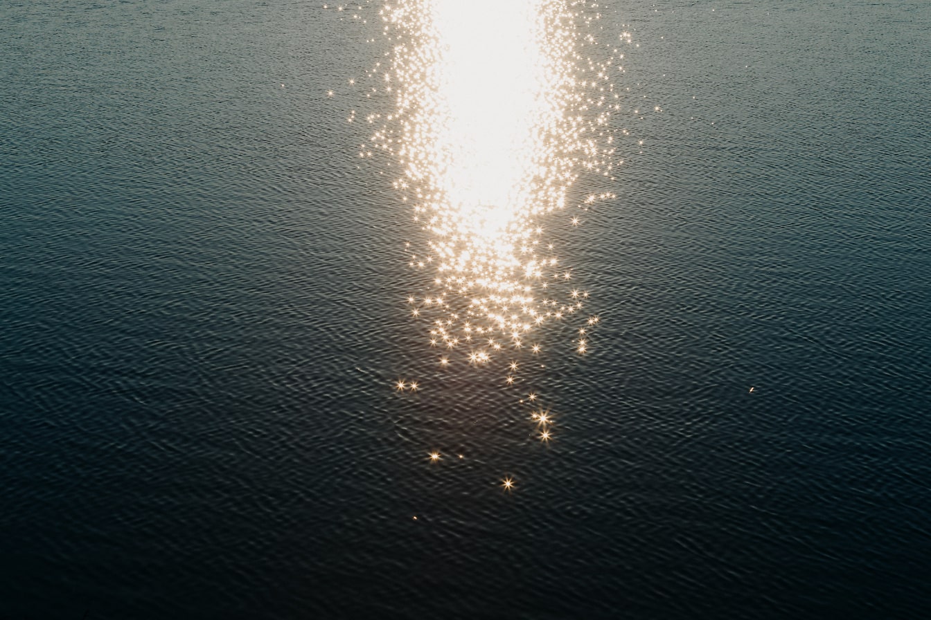 Funkelnde Sonnenstrahlen scheinen auf das Wasser