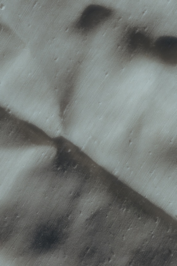 Close-up tekstur kain katun putih dengan bayangan di atasnya