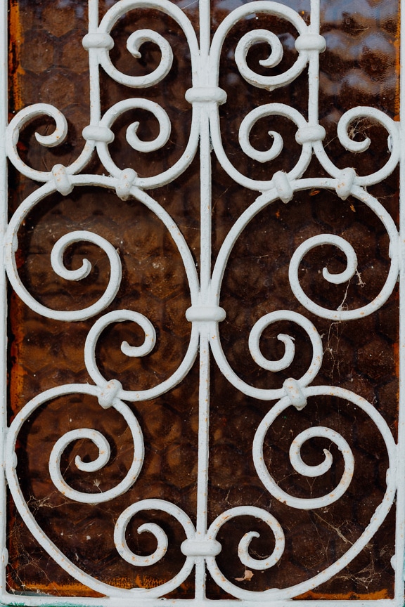 White cast iron protection over window with symmetric decorative swirls