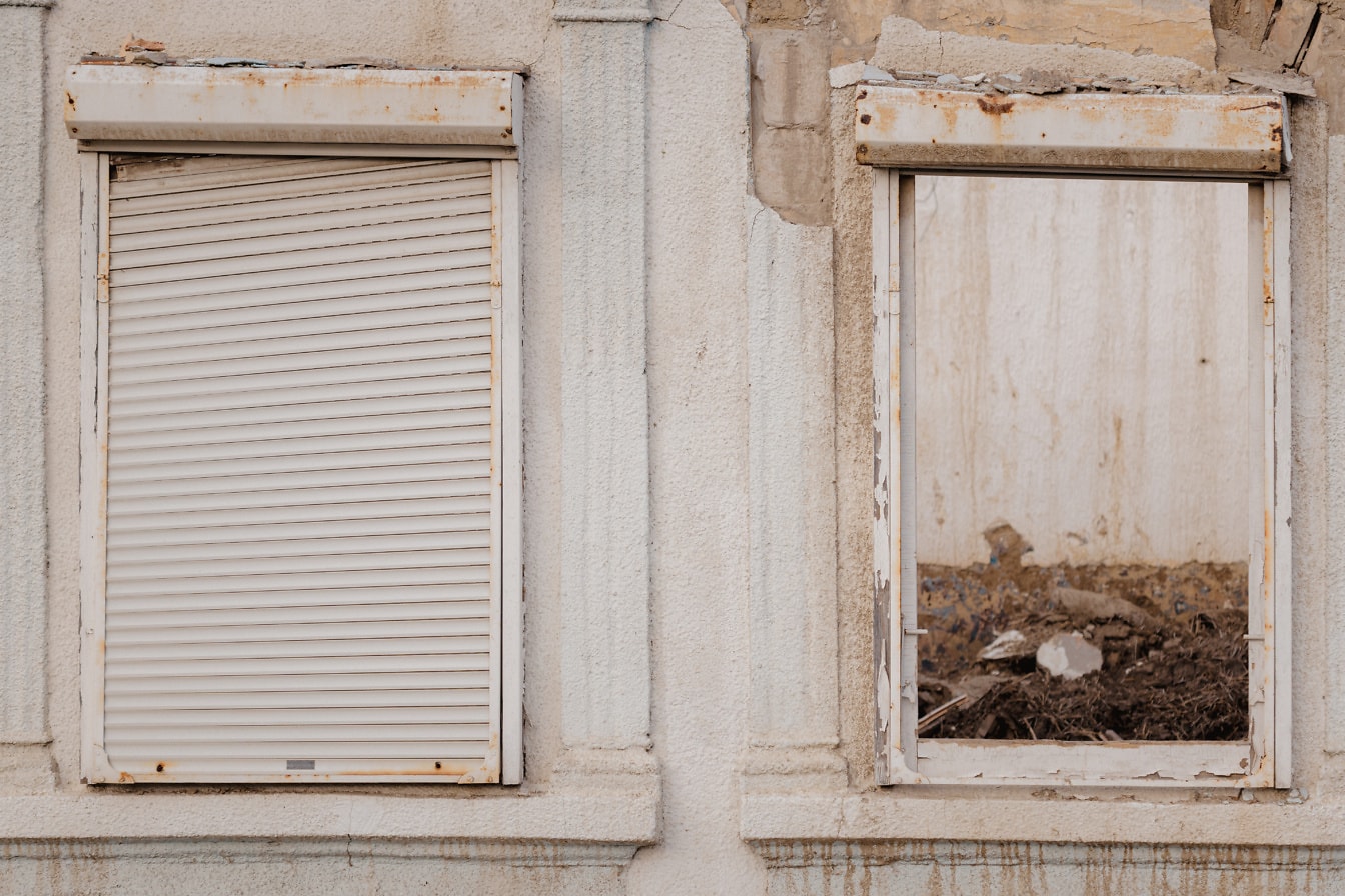 Hai cửa sổ mục nát vỡ của ngôi nhà bỏ hoang