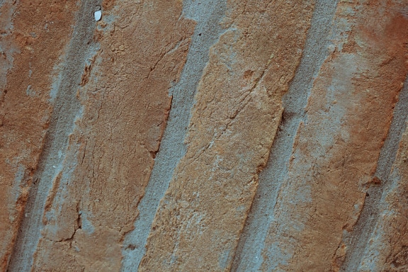 Nærbillede af en murstensvæg med rødlige mursten stablet diagonalt