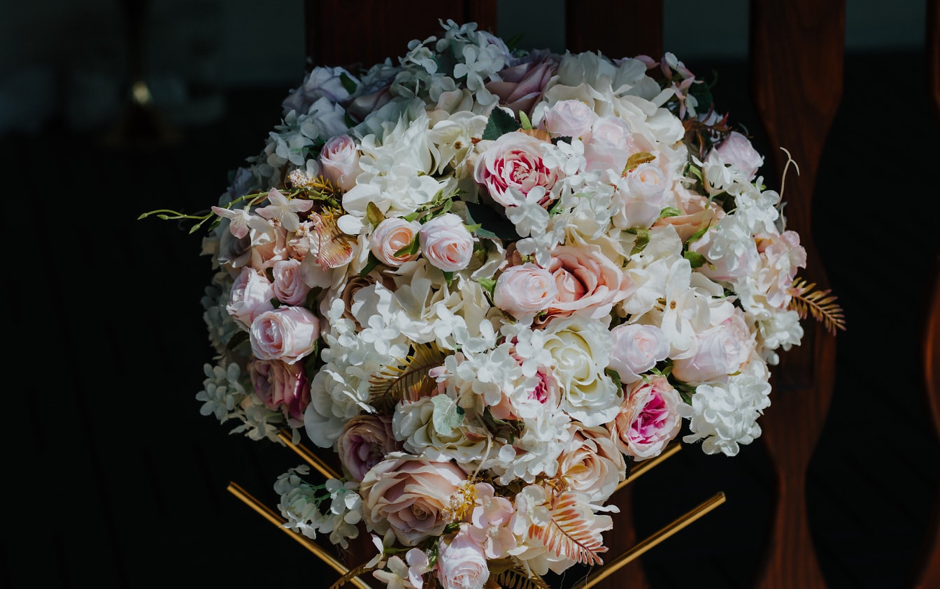 Bouquet di fiori di rosa bianchi e rosati in penombra