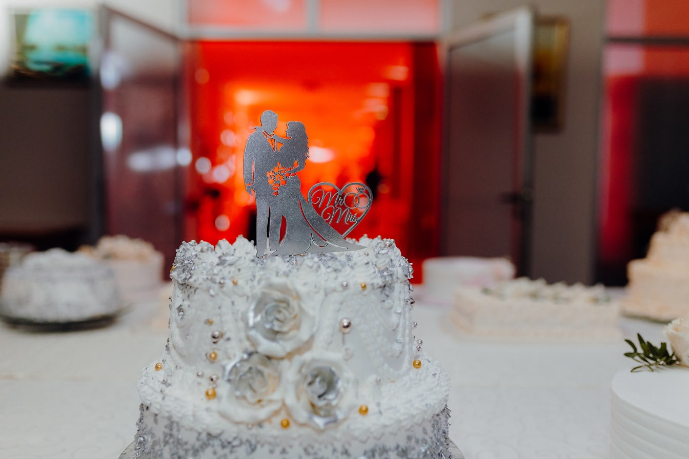 Bröllopstårta med figurer på toppen som illustrerar brud och brudgum