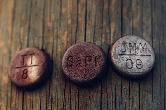 Rusty cast iron round metal objects with embossed label on them