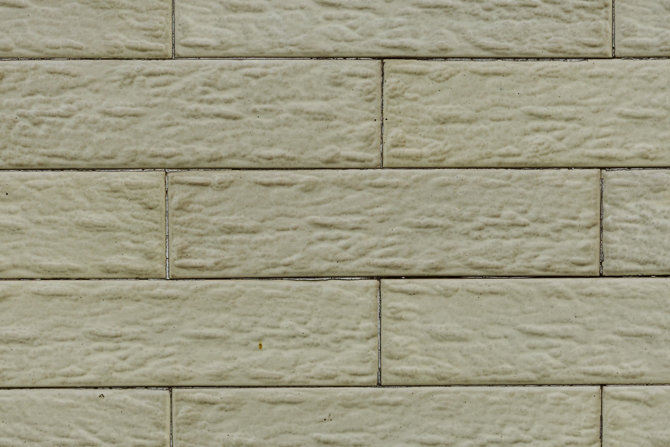 Tampilan close-up dinding dengan batu bata fasad horizontal kekuningan