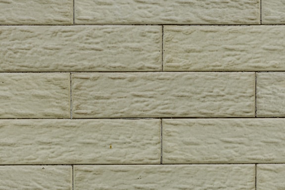 Close-up de uma parede com tijolos horizontais amarelados da fachada