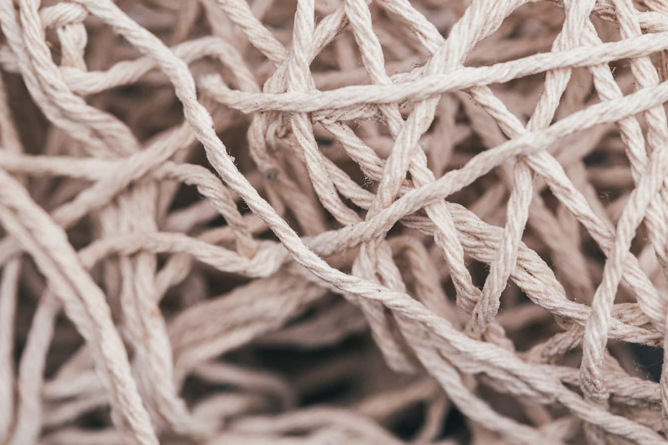 Detailní textura tenkých bílých bavlněných lanových vláken s uzly