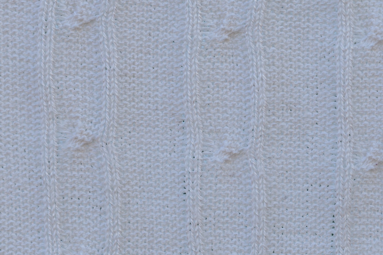Trama di un tessuto a maglia bianco fatto a mano con linee verticali