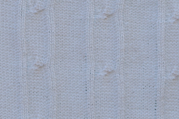 Textur eines weißen, handgefertigten Strickstoffs mit vertikalen Linien
