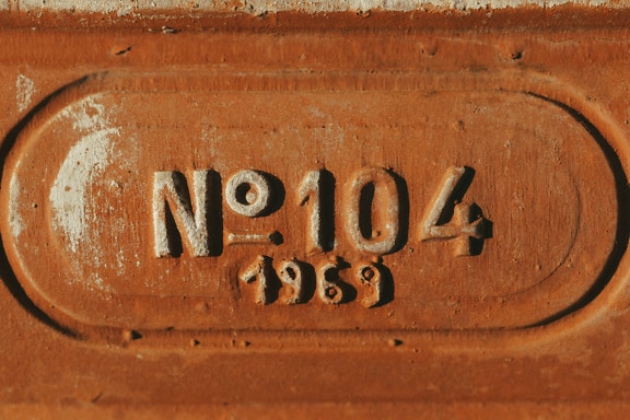 Primer plano de una fundición oxidada con indicación de fecha de producción (1969)