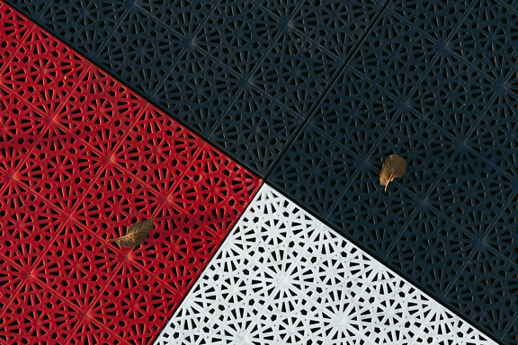 Black, red and white plastic floor coverings with geometric pattern