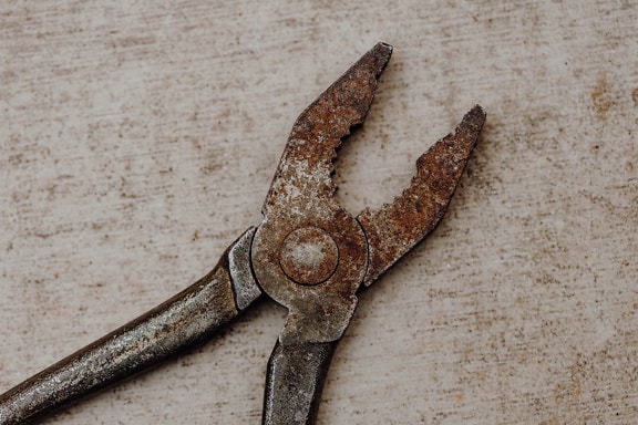 Rusty cast iron pliers on a table