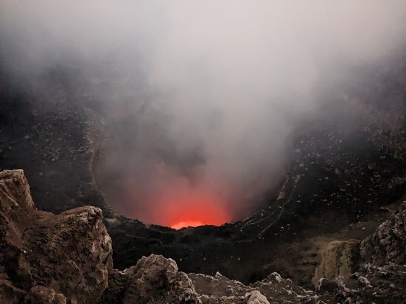 Erupção vulcânica com magma quente e vapor saindo da cratera vulcânica