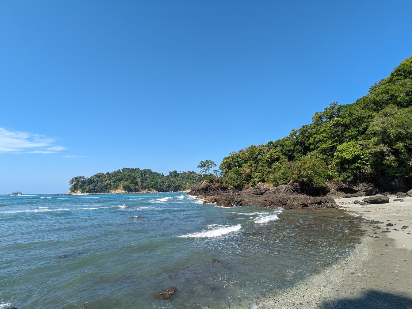 Pláž Manuel Antonio v přírodním parku Kostariky se stromy a skalami