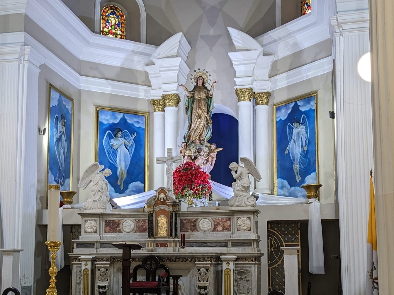 Standbeeld van de Maagd Maria met witte engelen in een kerk