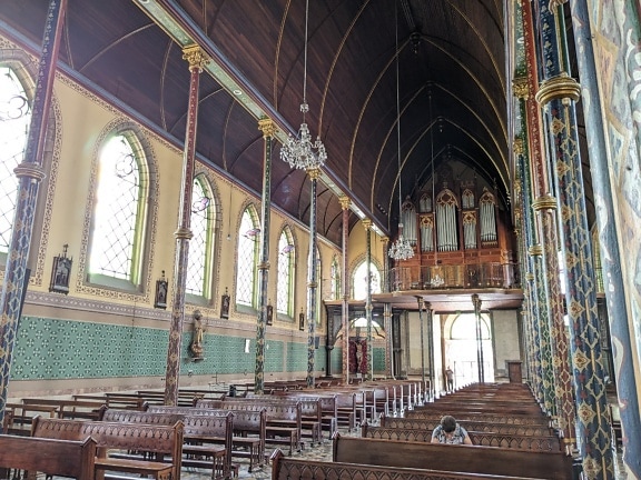 Chiesa di Nostra Signora della Misericordia con persona che prega su una panca e canne d’organo sullo sfondo