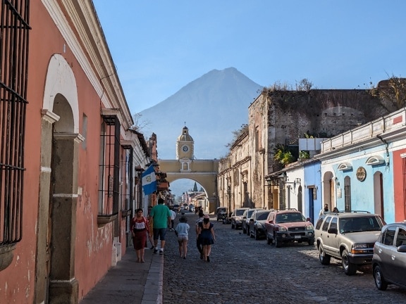Người dân đi bộ xuống một con đường lát đá cuội ở khu vực cũ của thị trấn ở Guatemala