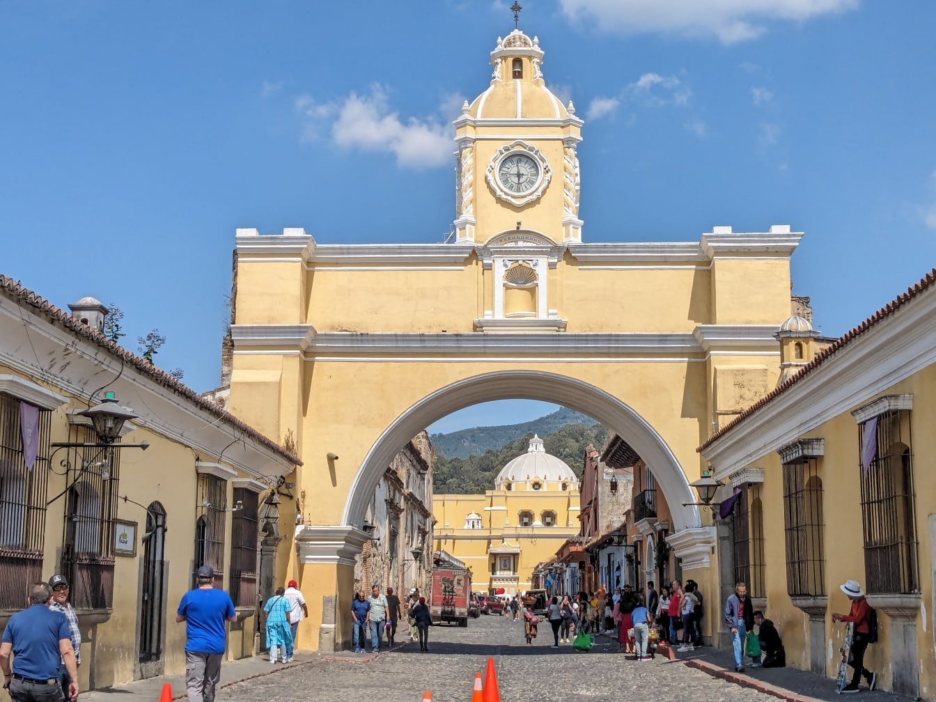 Santa Catalina Arch with a clock tower above road and people walking in the street