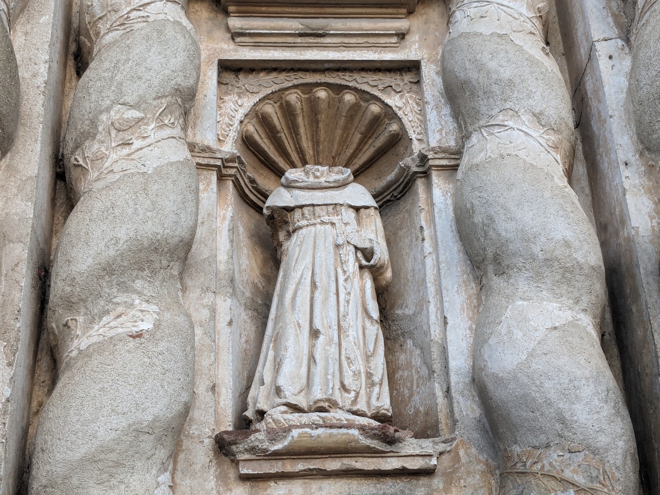 Kip redovnika bez glave u kamenom zidu