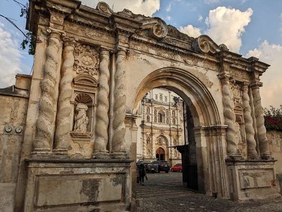 Kolonialer Torbogen mit Säulen und einer Steinstraße in Antiqua in Guatemala