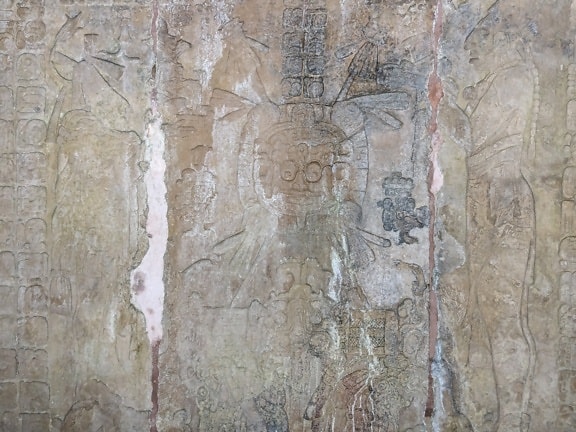 Каменна стена с дърворезби, изобразяващи цивилизацията на Мая