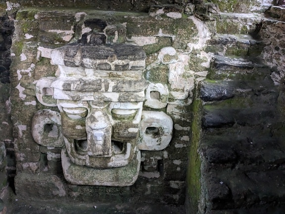 과테말라 티칼 (Tikal)의 마야 사원 (Mayan temple)에있는 쿠쿨칸 (Kukulkan)의 얼굴 돌 조각