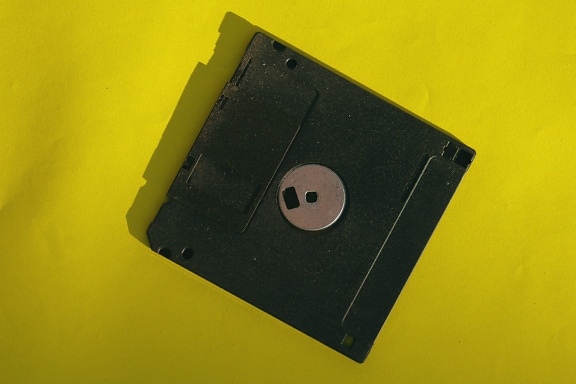 Black floppy disk on a yellow background