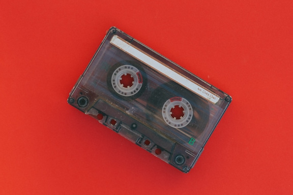 Old music cassette tape on a red background