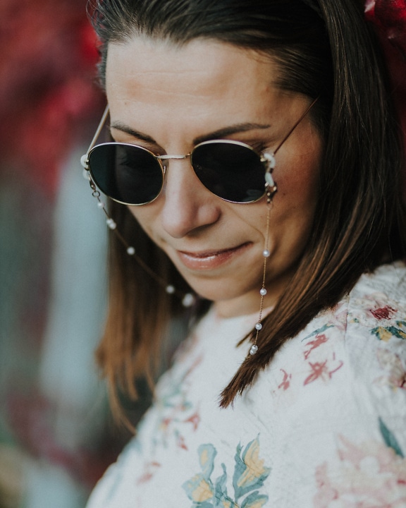 Portrait of brunette woman with pretty face wearing sunglasses