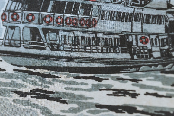 Közeli fénykép pamutszövetről, rajta egy hajó illusztrációjával