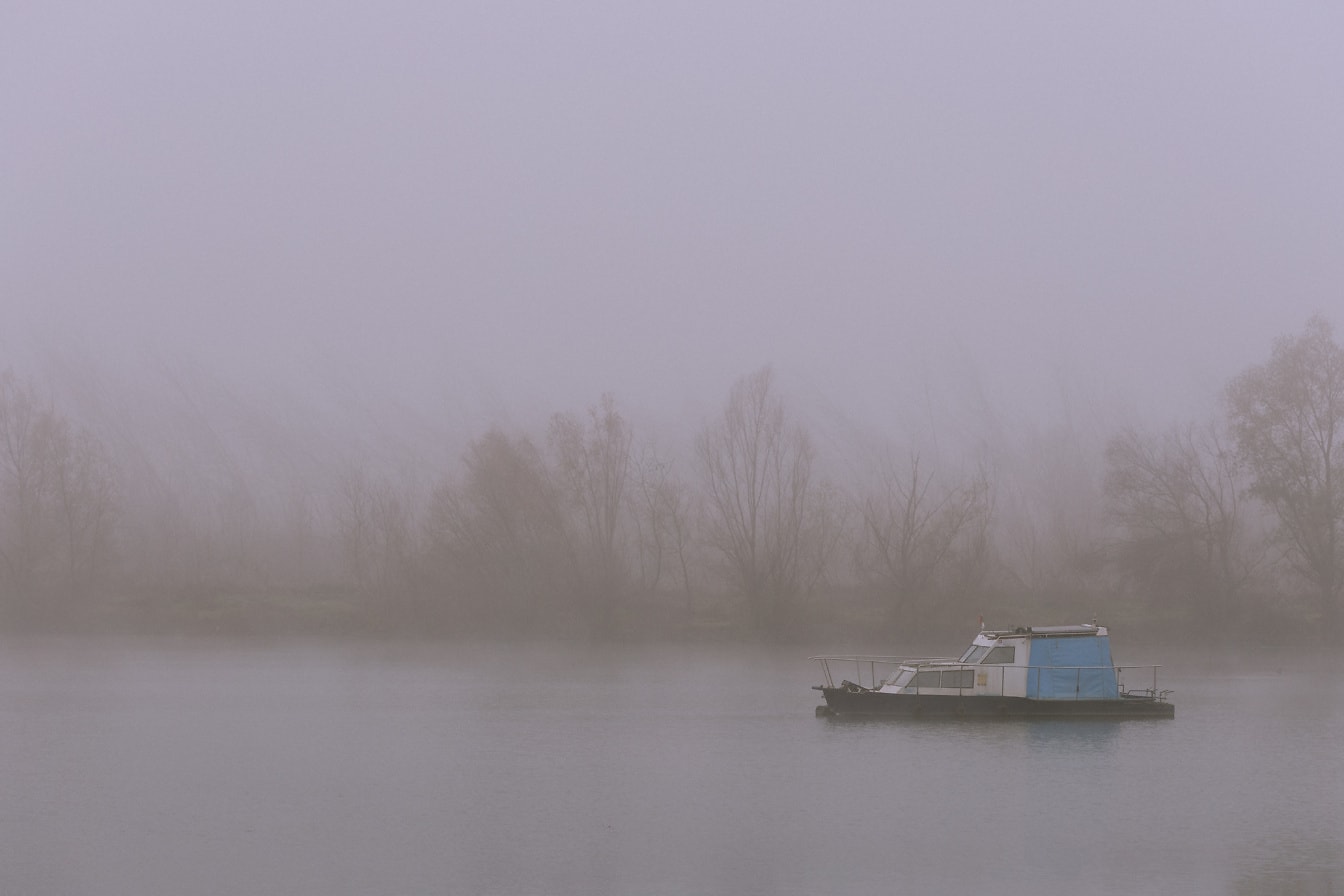 Perahu nelayan kecil di sungai Danube dalam kabut tebal