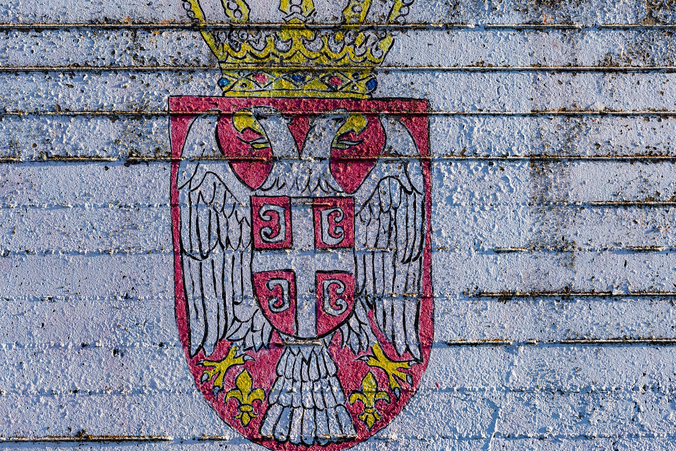 Graffiti del escudo de armas de Serbia con un águila blanca de dos cabezas en una pared de hormigón