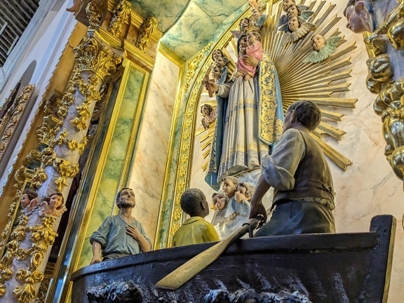 Staty av människor i en båt med en paddel i nisch av altare i katolsk kyrka