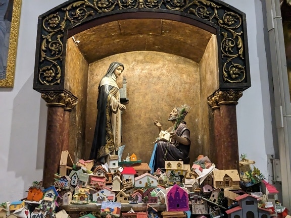 Estatua de un hombre y una mujer en el nicho de la iglesia de gracia con casas en miniatura