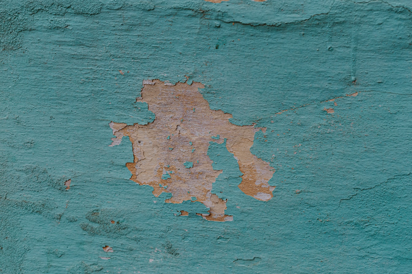 Grov tekstur af væggen med turkis kalk, der falder af