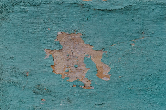 Rough texture of the wall with turquoise lime that falls off