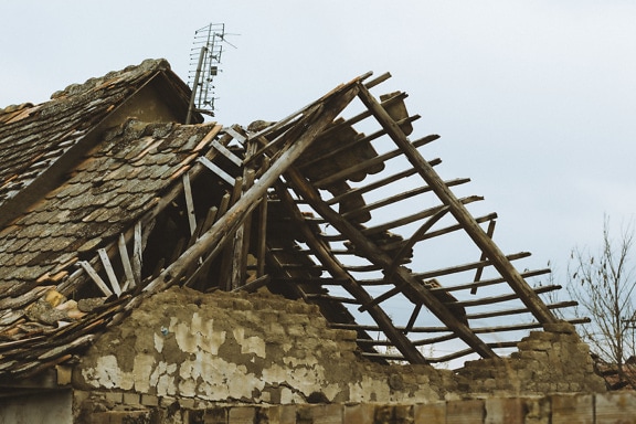 Topraktan yapılmış tuğla duvarlı eski bir evin kırık çatısı