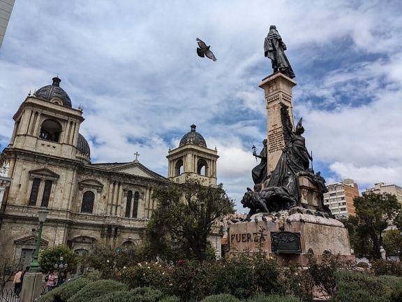 Statue på Murillo-plassen i byen La Paz i Bolivia foran en basilika for Vår Frue av Fred
