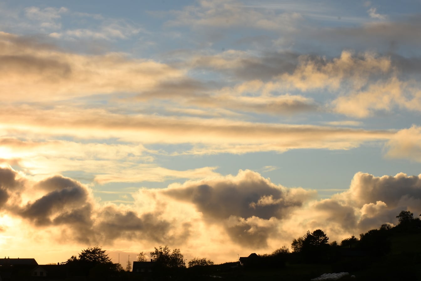 Слънчево утро с облаци в небето над населеното място