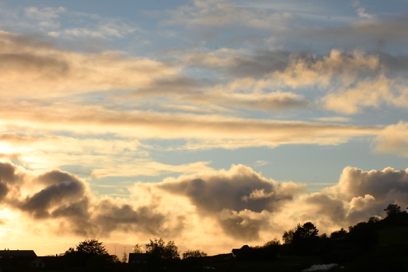 Słoneczny poranek z chmurami na niebie nad osadą