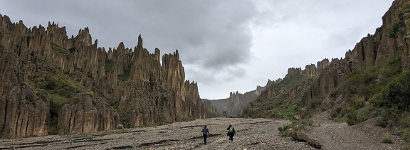 People hiking through the valley of the souls on a dry rocky riverbed