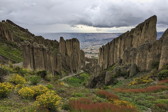 Panorama de formaciones rocosas con altos acantilados en el valle de las almas y una ciudad al fondo