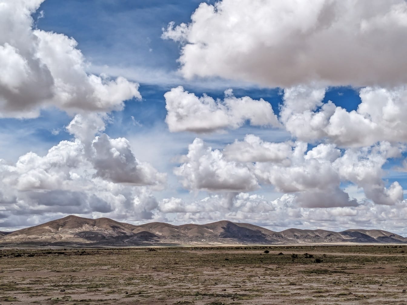 Lanskap gurun Amerika Latin dengan pegunungan dan awan